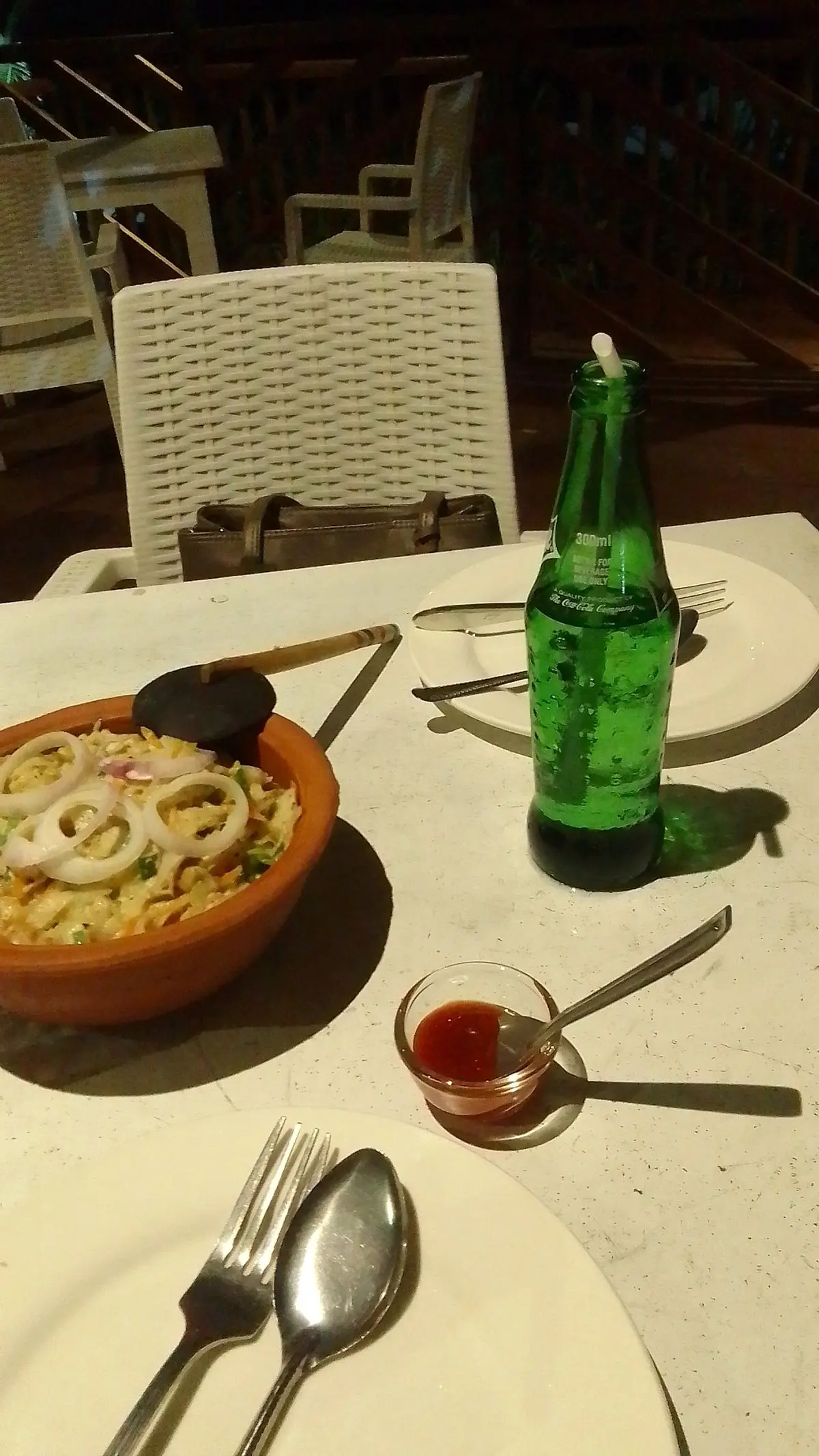 Rice dish with onion rings in a clay bowl and a fresh lime soda