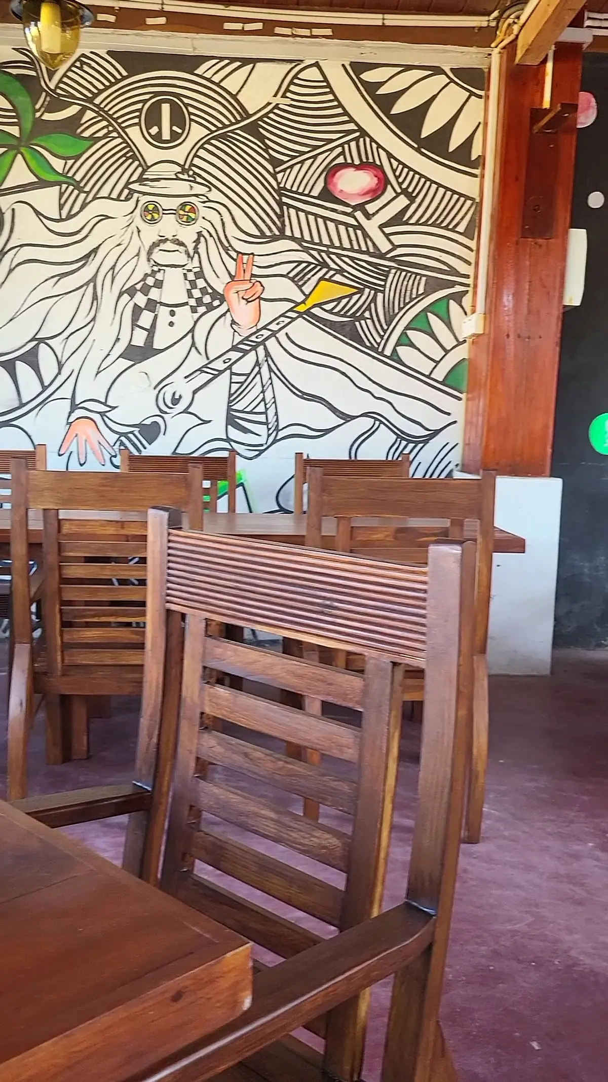 Indoor dining room with timber chairs and a black-and-white mural