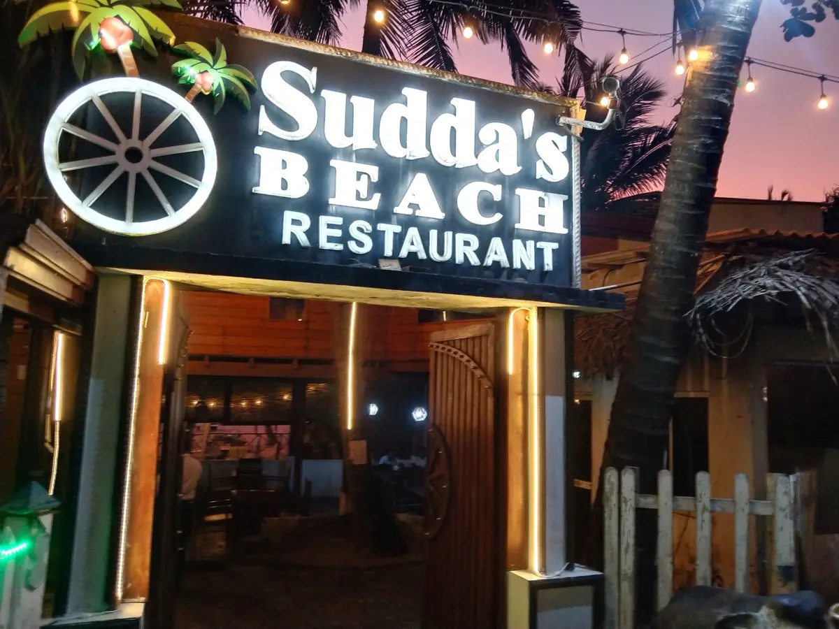 Illuminated Sudda's Beach Restaurant sign at night